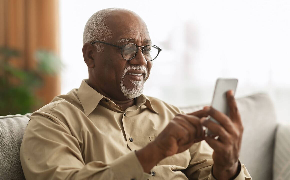 elderly man uses cell phone to verify his identity