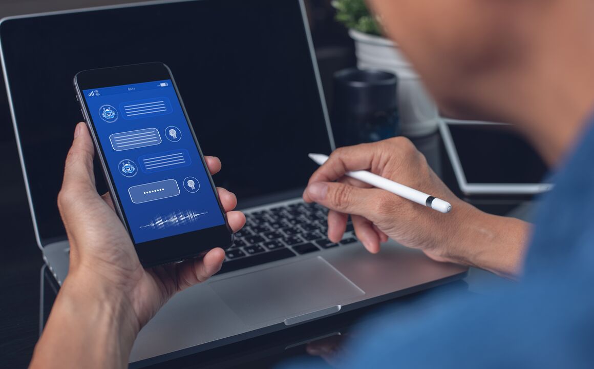 An agent texts with a citizen while using a laptop