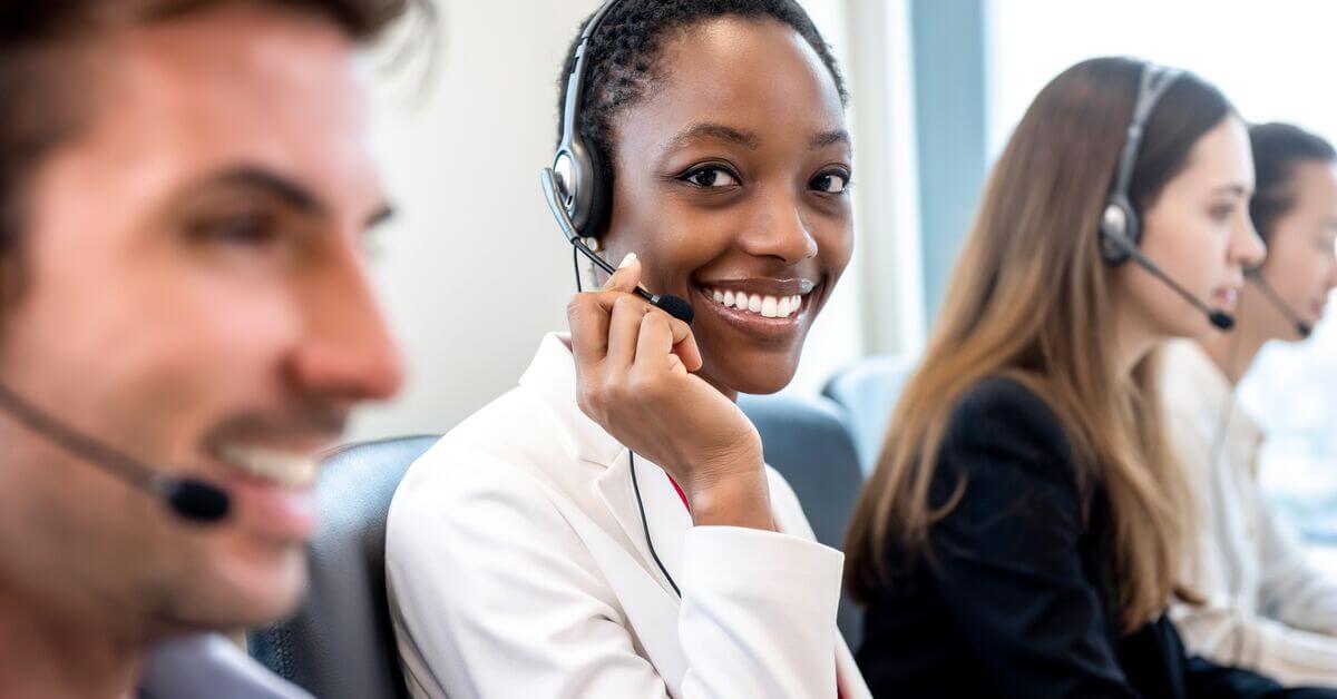 African American woman working in call center office with diverse team