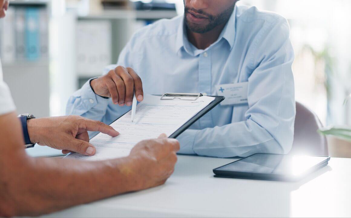 Pharmacist and patient review medical chart