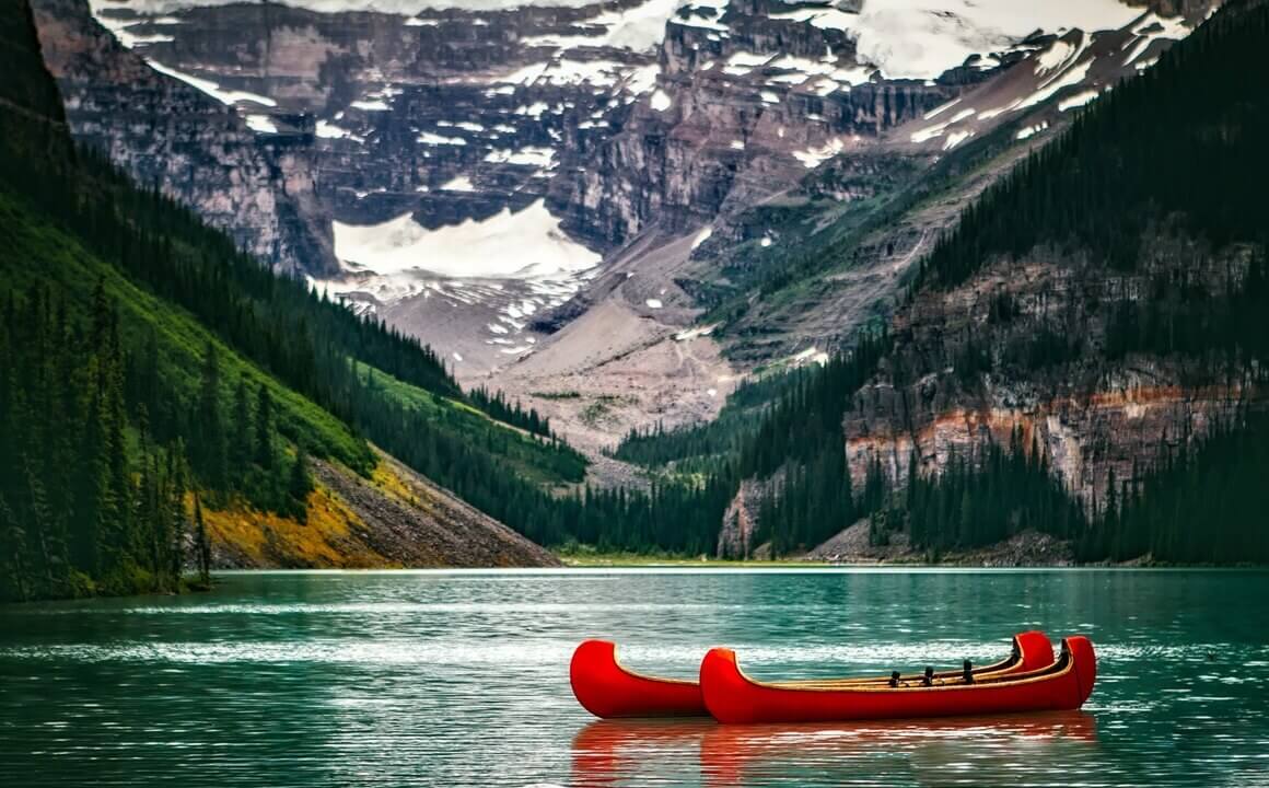 A Canadian lake with a snow-capped mountain and forest in the background..