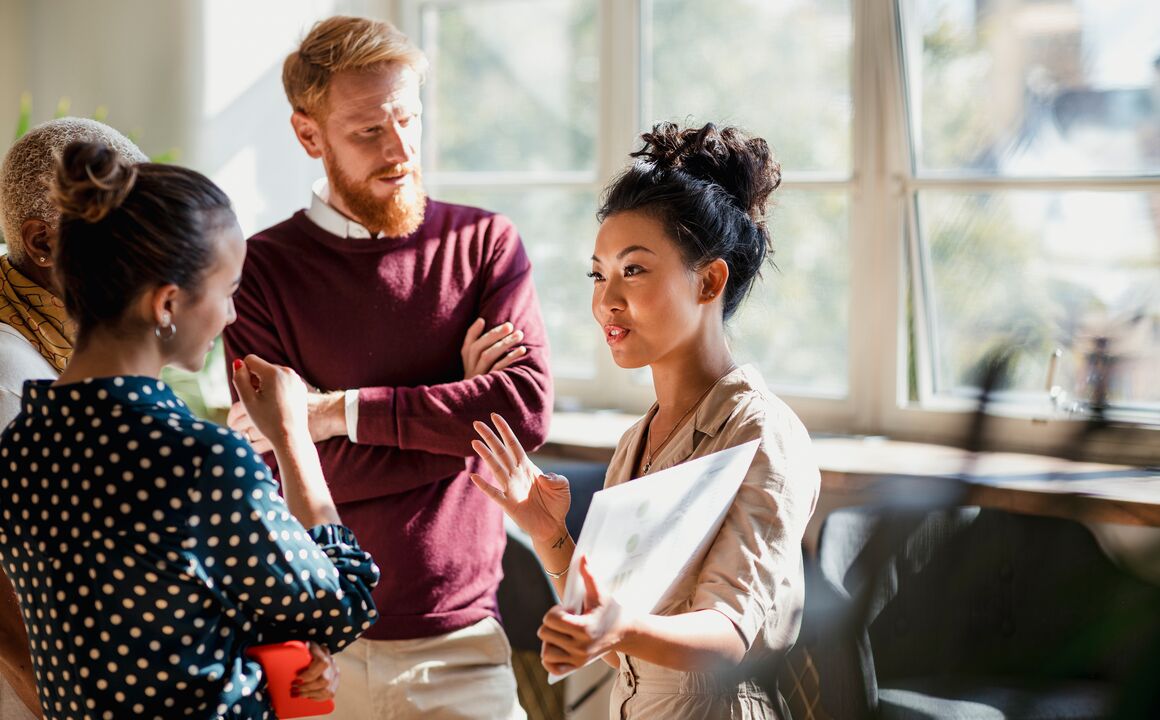 a diverse team discusses business in a sunlit office